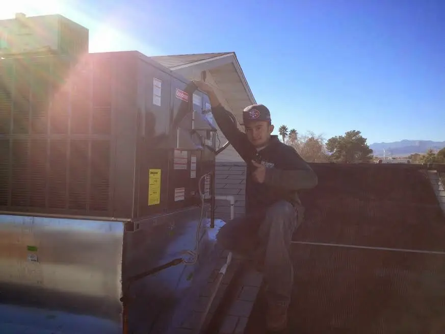 HVAC technician performing AC Tune-Up on a rooftop unit in Lakehills